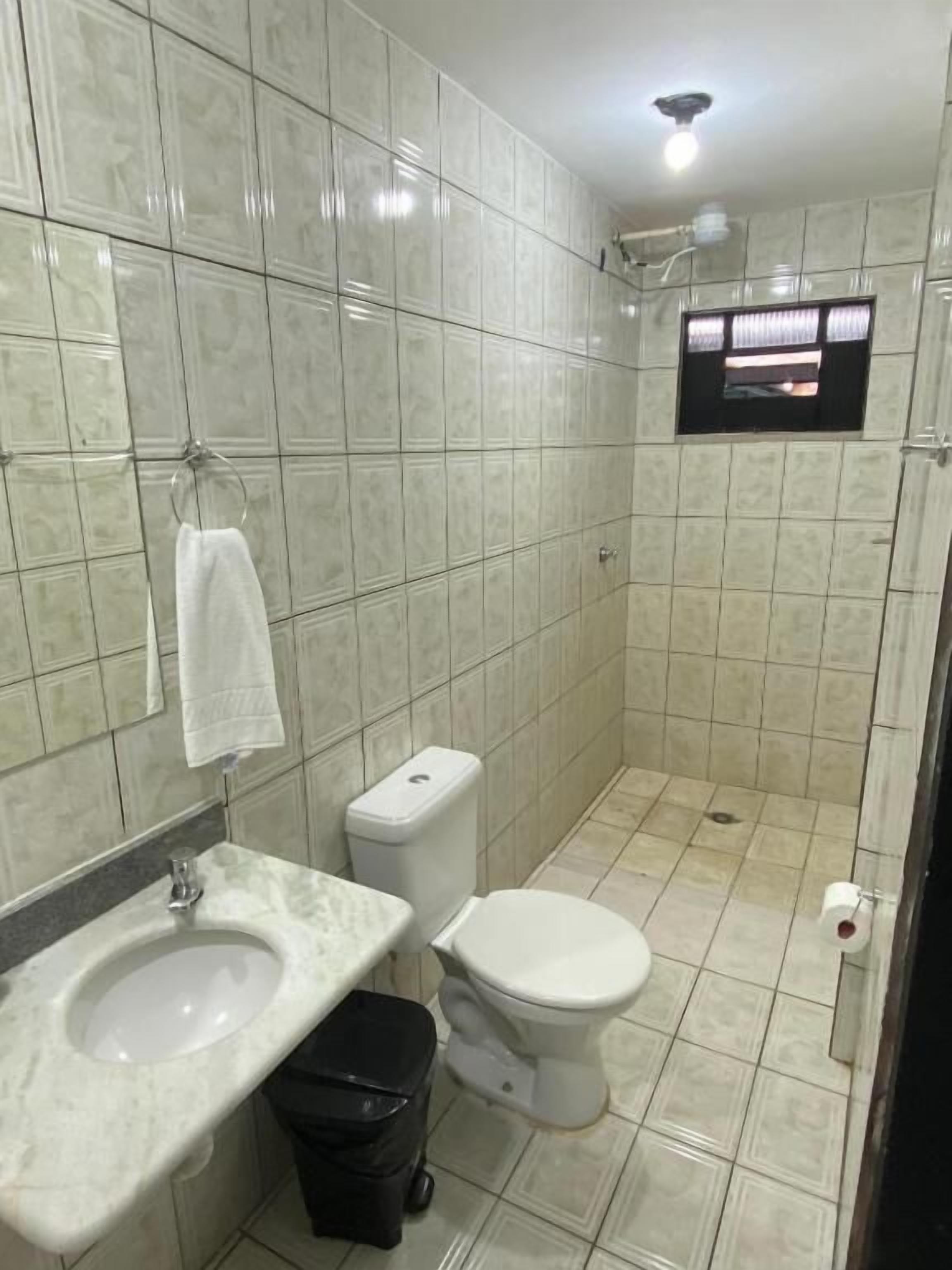 A bathroom with a toilet, sink, and shower.