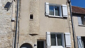 A two-story building with a stone facade, a central entrance with a door, and a small window above the door. - Vitis Vinifera, Pour une escapade œnologique en famille (Deux Rivières)