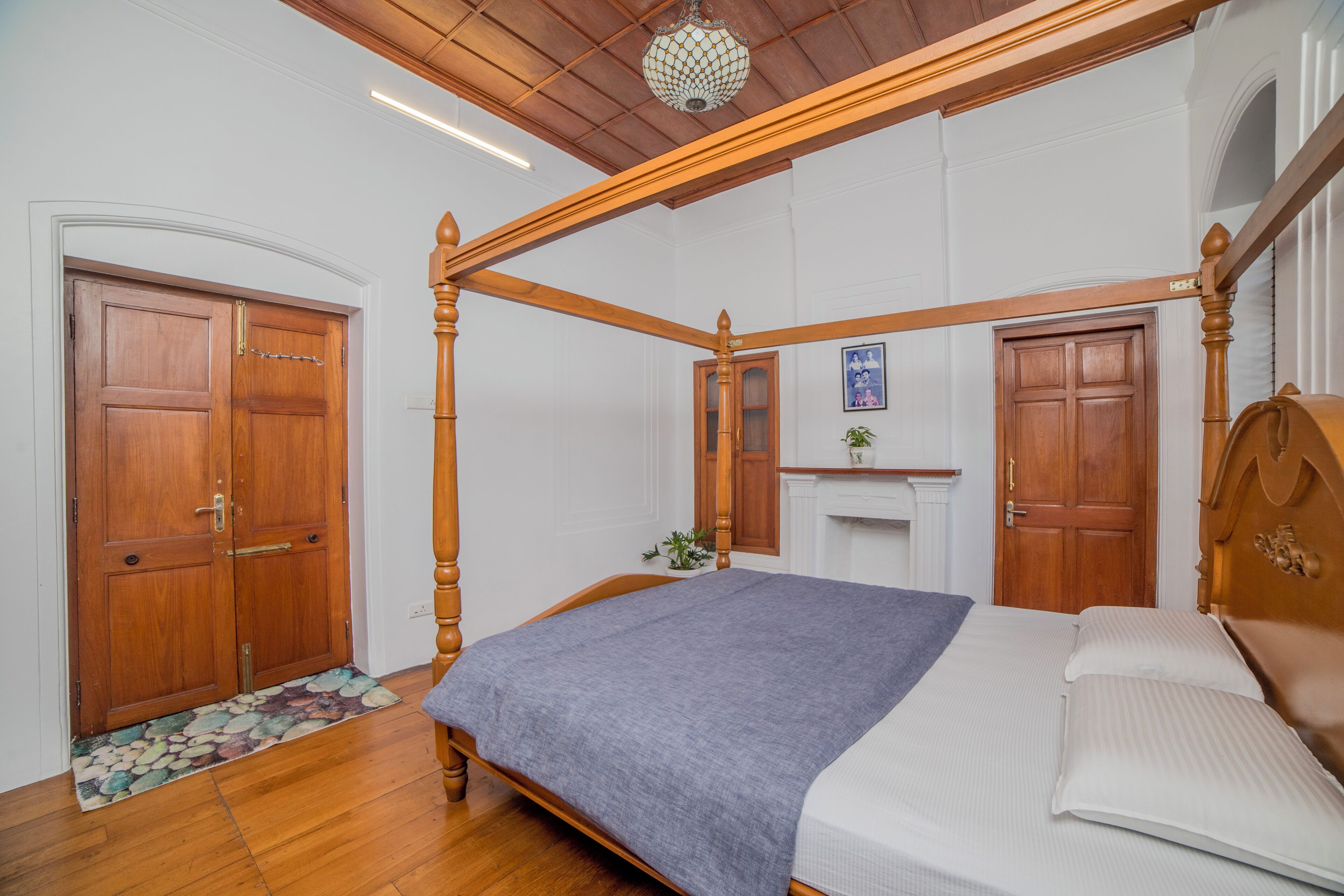 Ein Schlafzimmer mit Himmelbett, Holzboden und Kamin.