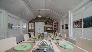 Un comedor con una mesa larga dispuesta para varias personas, rodeada de sillas.