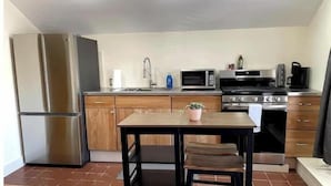 Une cuisine compacte équipée d’un réfrigérateur, d’un four à micro-ondes, d’une cuisinière et d’un évier.