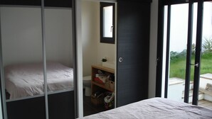 Un dormitorio con cama, armario y baño pequeño.