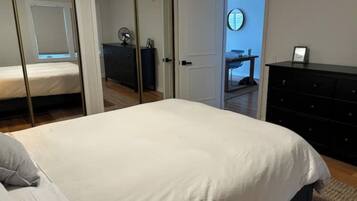 A bedroom with a bed, a dresser, and a mirror on the wall.
