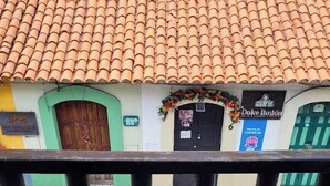 A balcony with a tiled roof, a wooden door, and a sign for 'Dulce Miluna.'