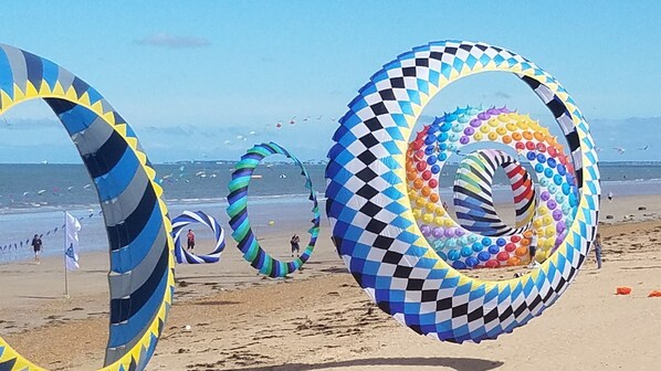 En strand med store, farverige, spiralformede drager.