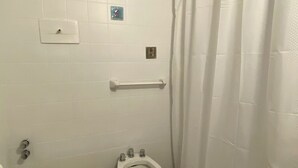 A small bathroom with a toilet, bidet, and a shower curtain.