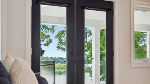 Un dormitorio con cama, ventana y vistas a árboles y un edificio.