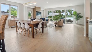 Un amplio salón con mesa de comedor, sofás y un ventanal que ofrece vistas al exterior.
