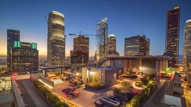 Ein modernes Hochhaus mit Dachgarten und Außenbereich zum Sitzen.