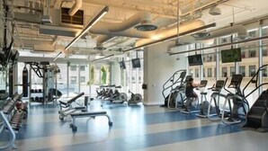 Ein Fitnessraum mit unterschiedlichen Trainingsgeräten, darunter Laufbänder und Kraftgeräte.