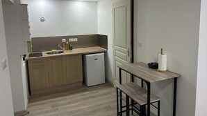 A compact kitchen with wooden cabinets, a small sink, and a built-in dishwasher.