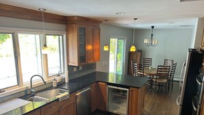 A modern kitchen with wooden cabinets, a black countertop, and stainless steel appliances.