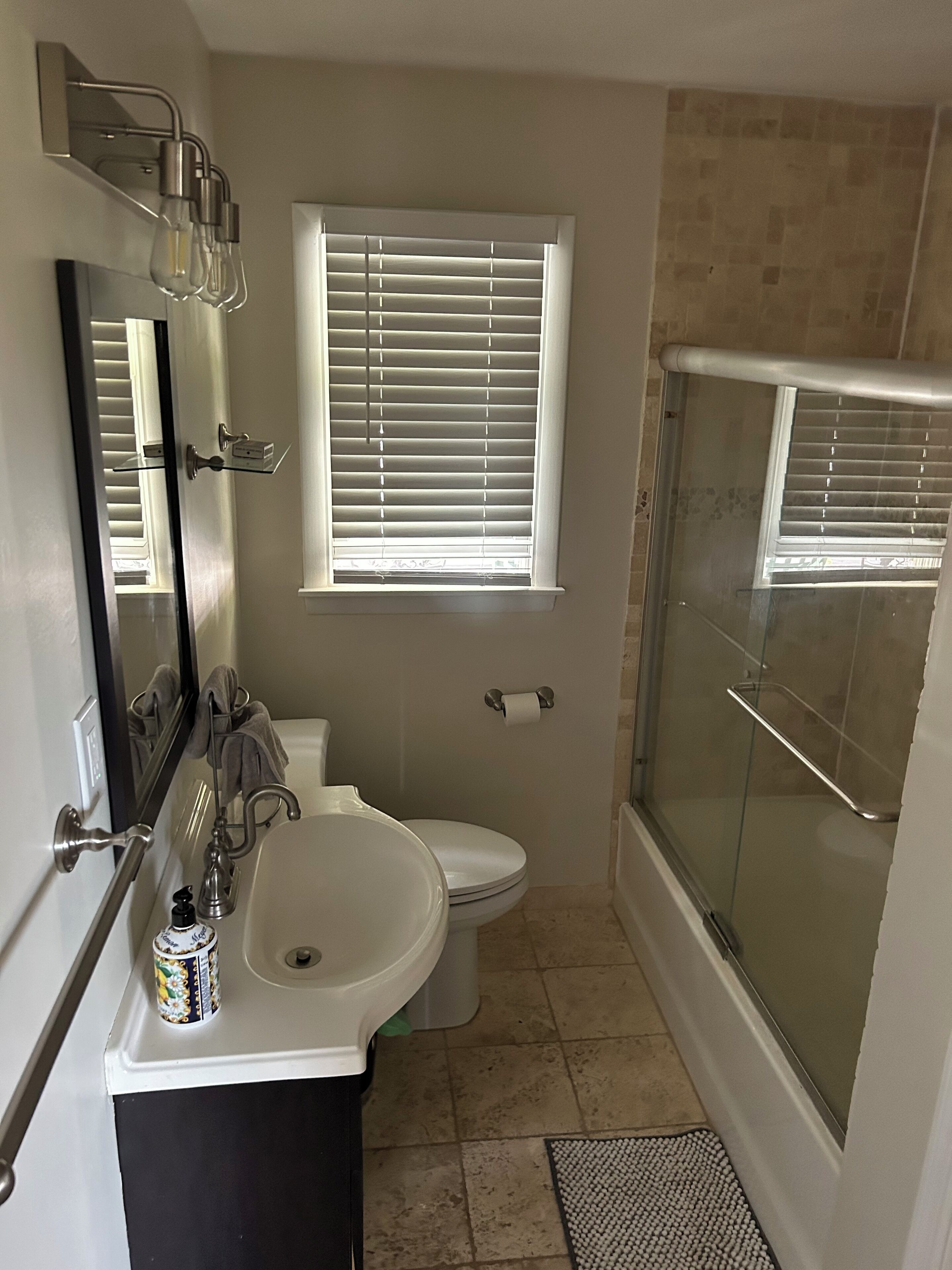 A bathroom with a toilet, sink, and shower.