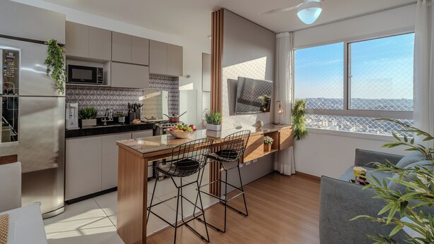A modern kitchen with a central island, bar stools, and a large window offering a city view. - Arena MRV, 2 quartos,vaga | Brazilian Corner (Belo Horizonte)