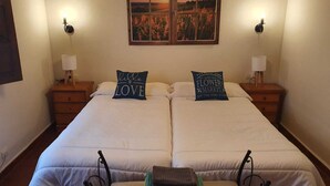 A double bed with two pillows, a bedside table with a lamp, and a wall-mounted picture. - LAS MIMOSAS DEL NALON (Soto Del Barco)