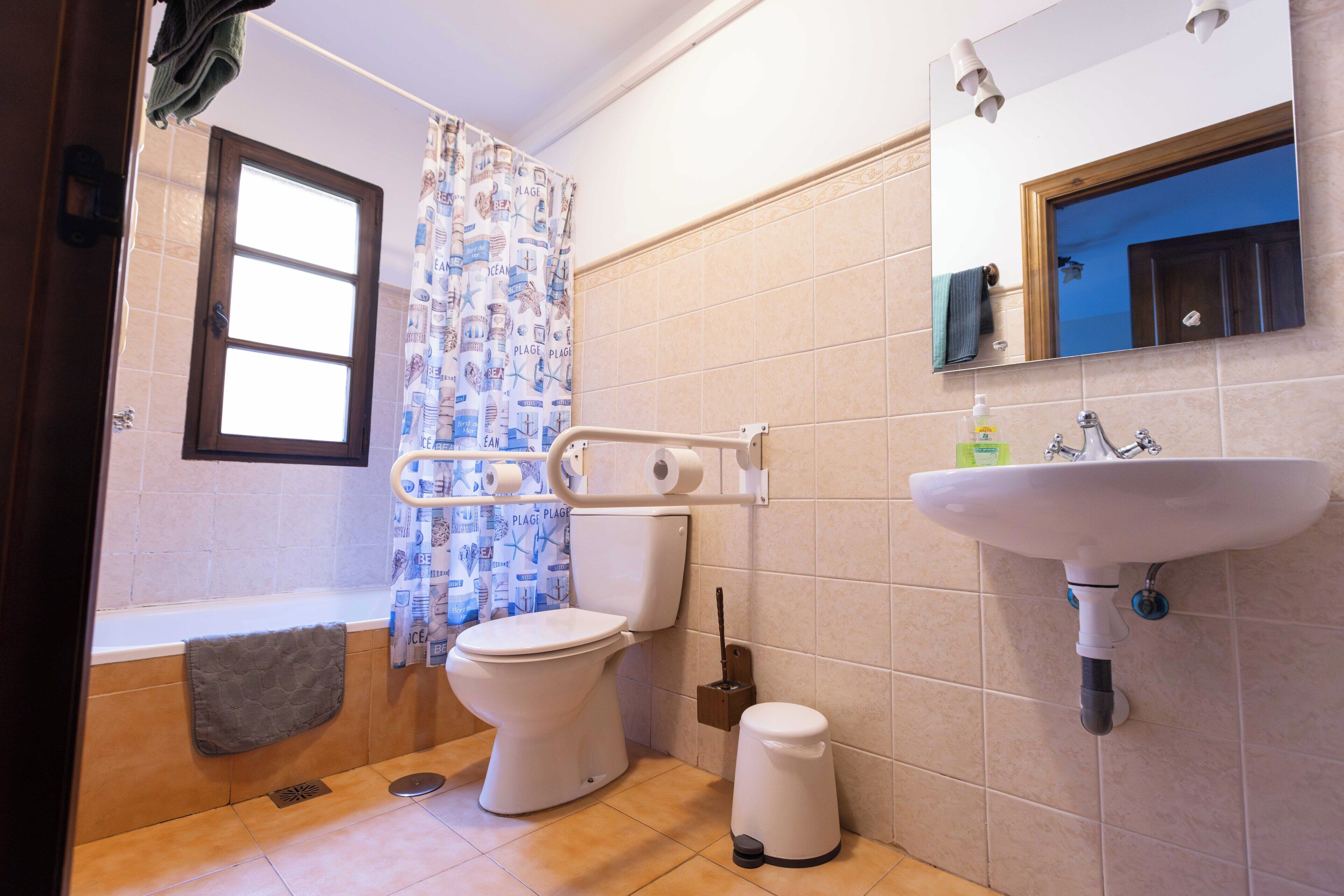 Un baño con inodoro, lavamanos y ducha.