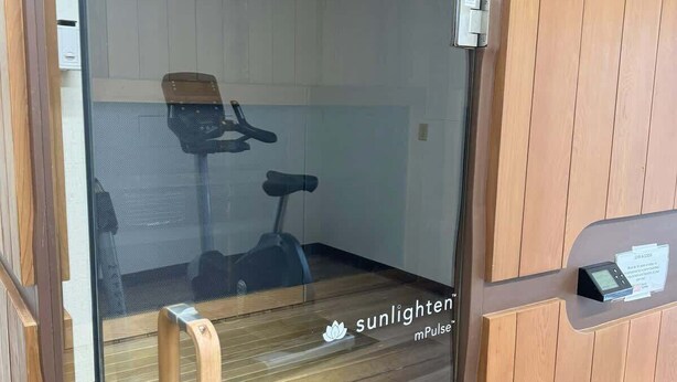 Ett ångrum med en träb änk, en massagestol och en kontrollpanel.