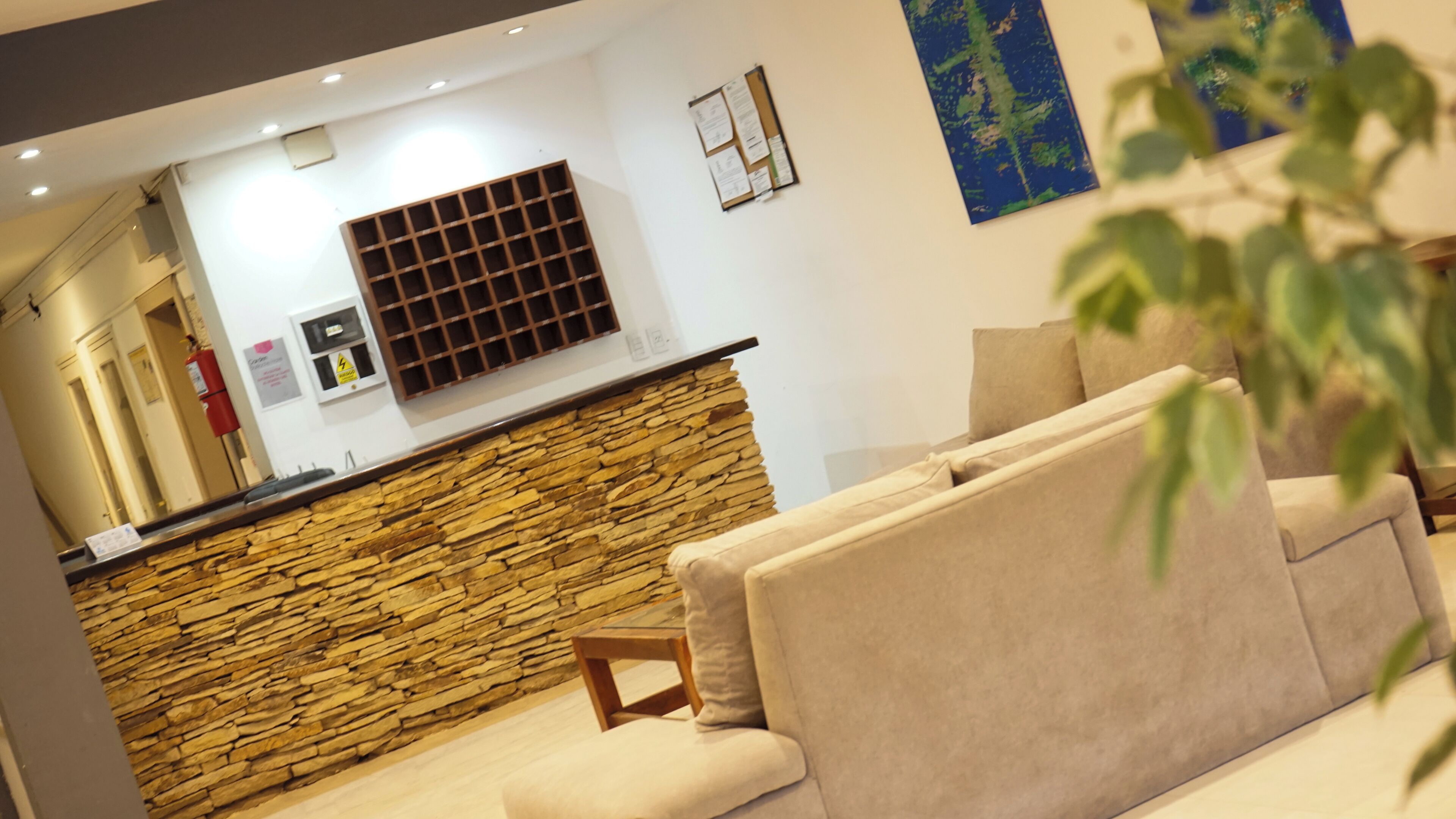 A modern living room with a stone accent wall, a built-in kitchen area, and a large window.