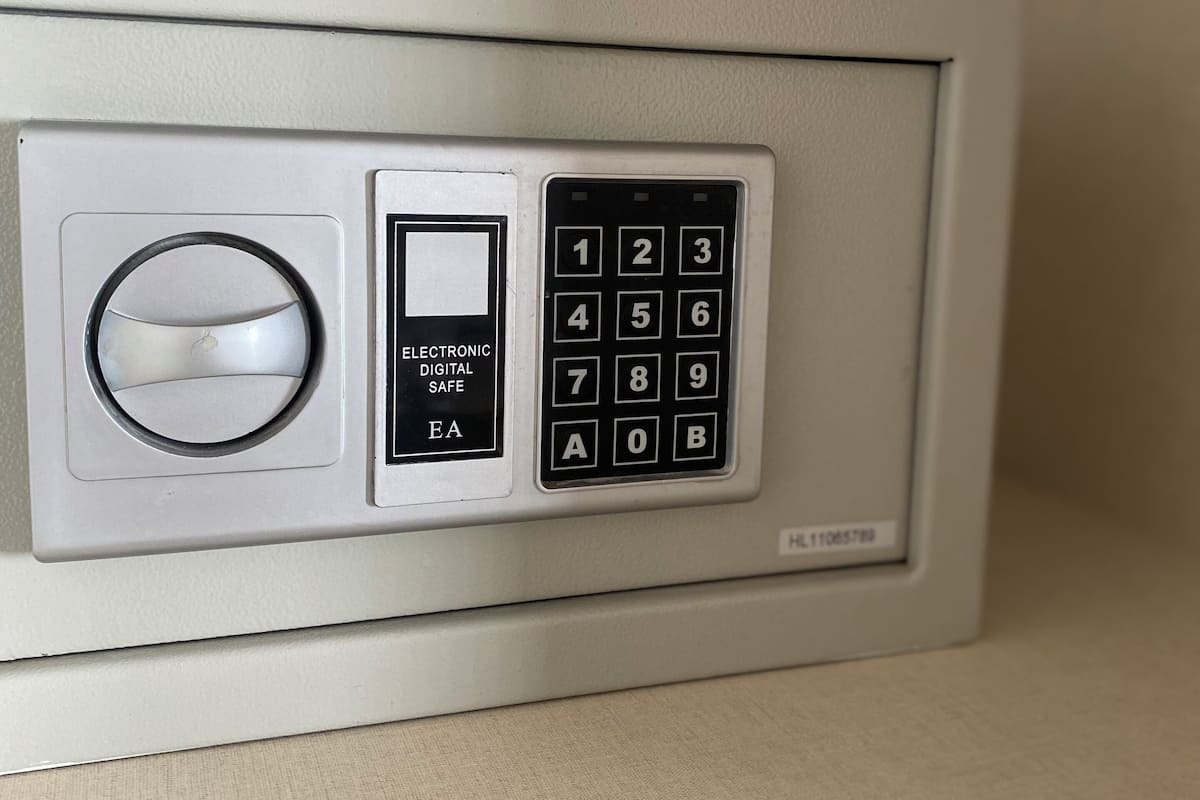 A wall-mounted electronic safe with a numeric keypad and a circular lock mechanism.