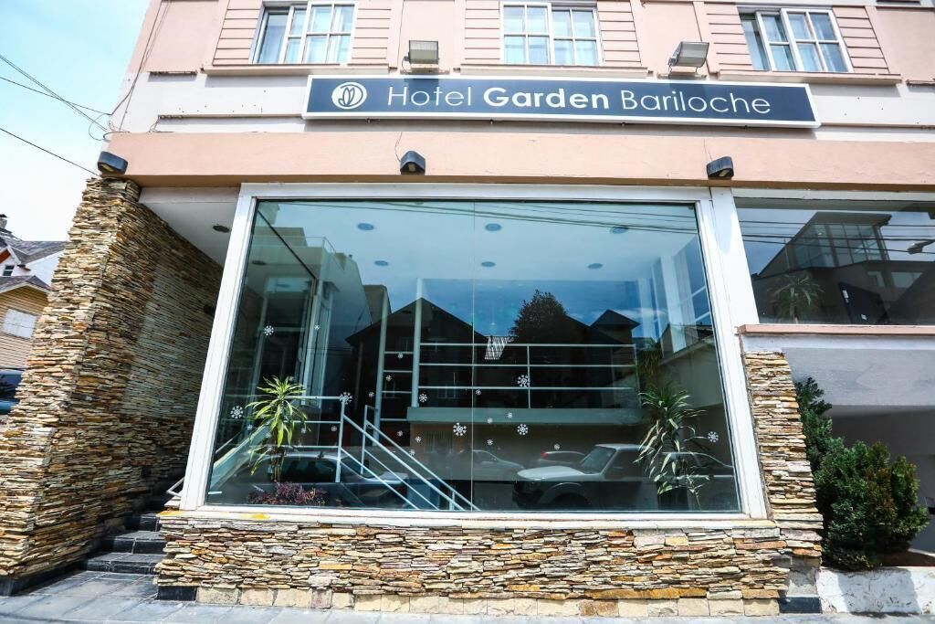 Hotel Garden Bariloche with a modern facade, stone accents, and a clear glass entrance.