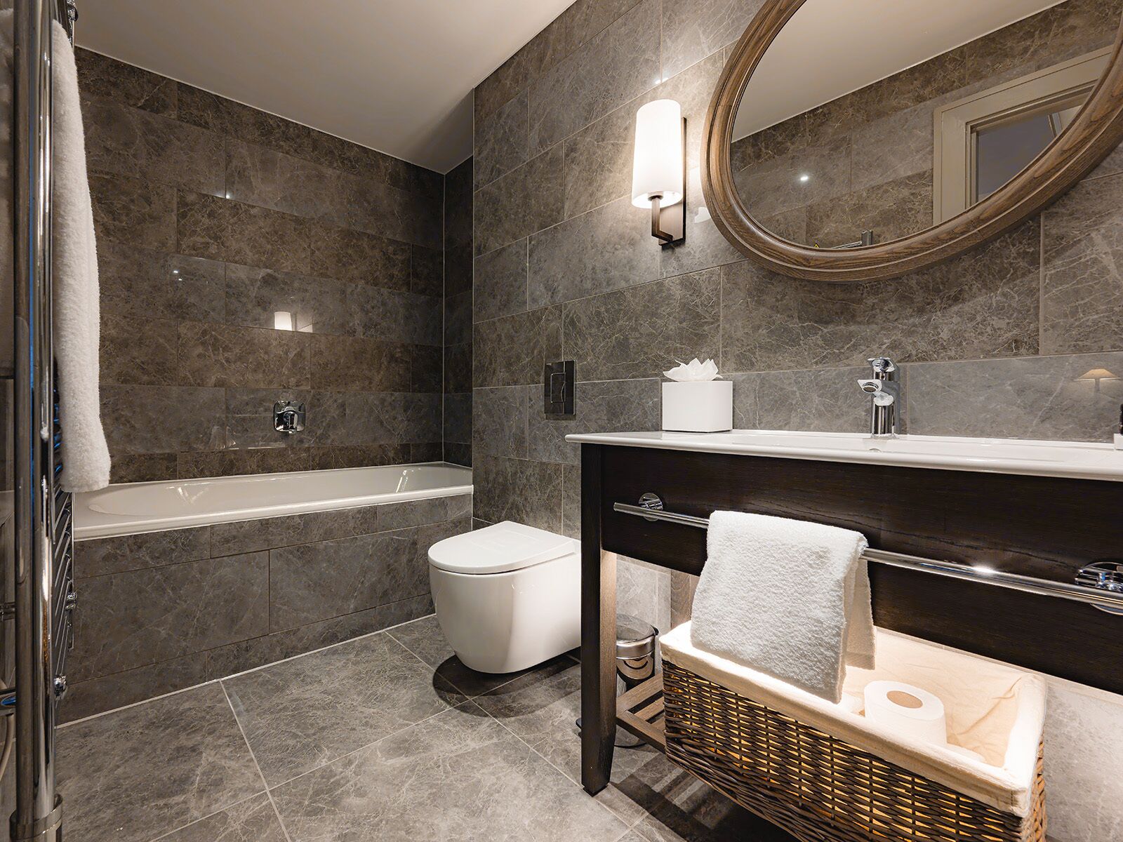 A modern bathroom with a bathtub, toilet, and vanity.