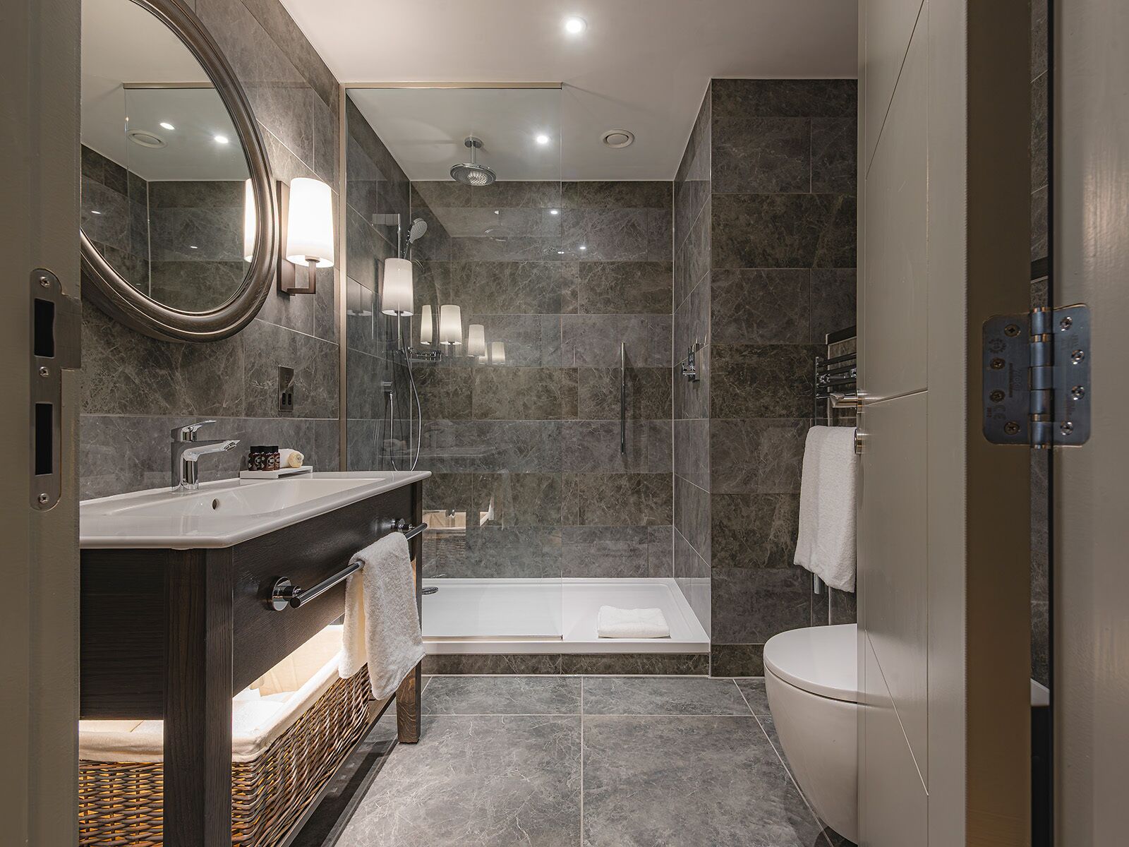 Un baño moderno con ducha de vidrio, una bañera independiente y un tocador con espejo.