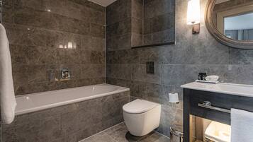 Une salle de bain moderne avec une baignoire, des toilettes et un meuble-lavabo.