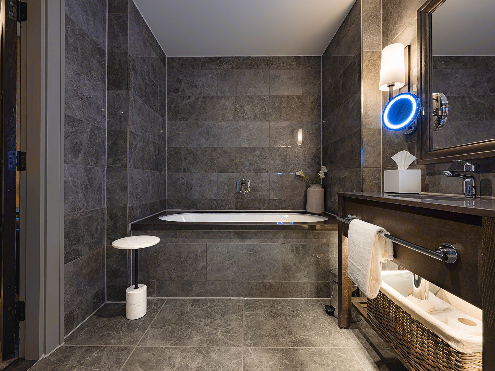 A modern bathroom with a freestanding bathtub, a vanity with a mirror, and a toilet.