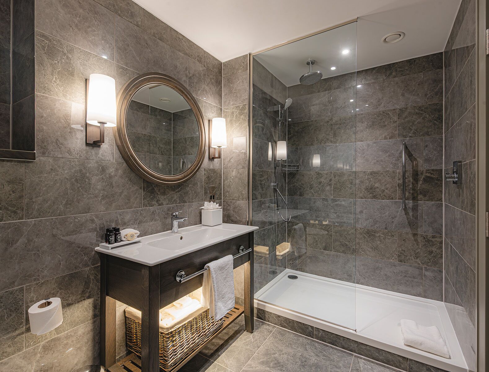 A modern bathroom with a large mirror, a vanity with a sink, a shower enclosure, and a bathtub.