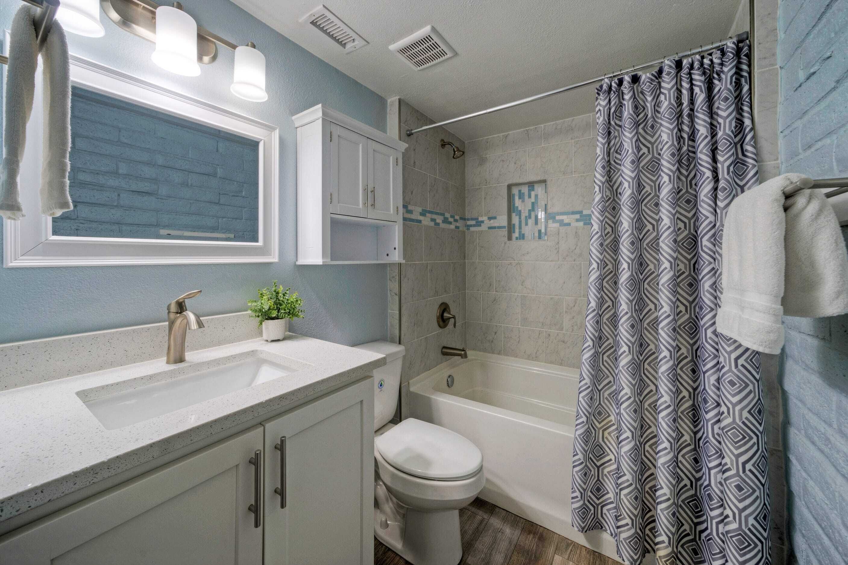 A bathroom with a sink, toilet, and bathtub.