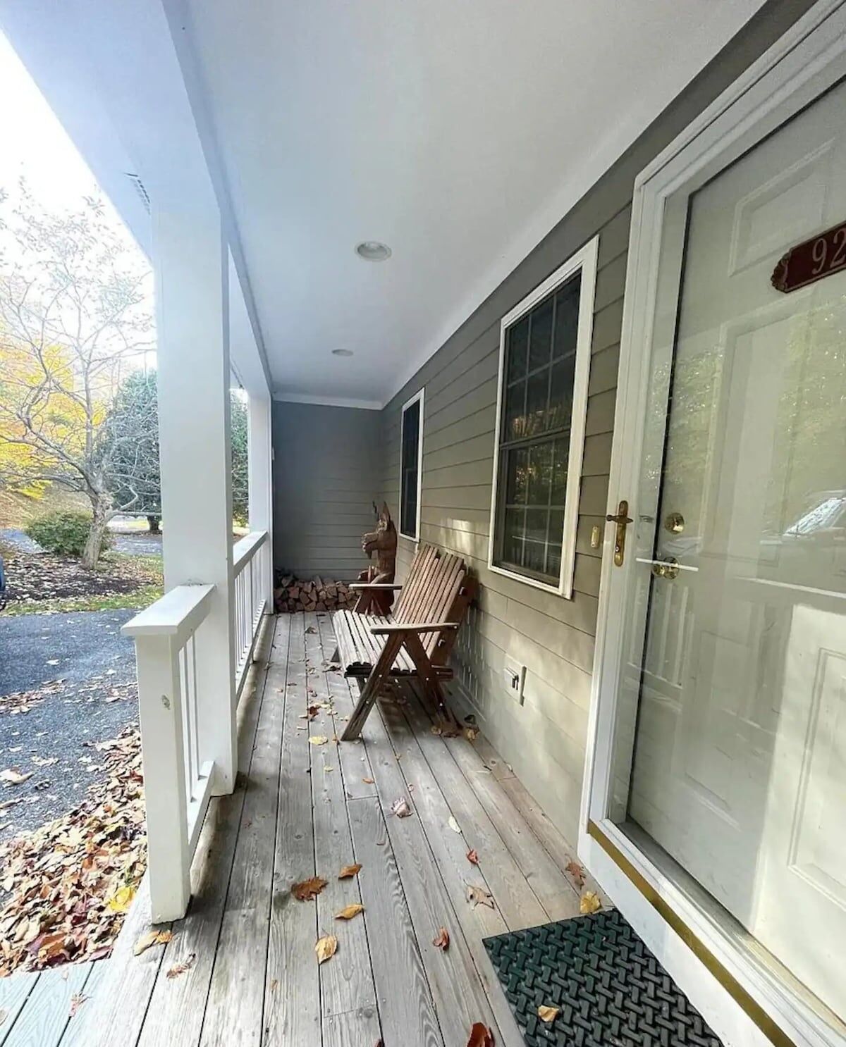 A porch with a bench, a door, and a window.