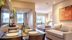Ein modernes Hotelzimmer mit Essbereich, einer Couch und einem Bett.