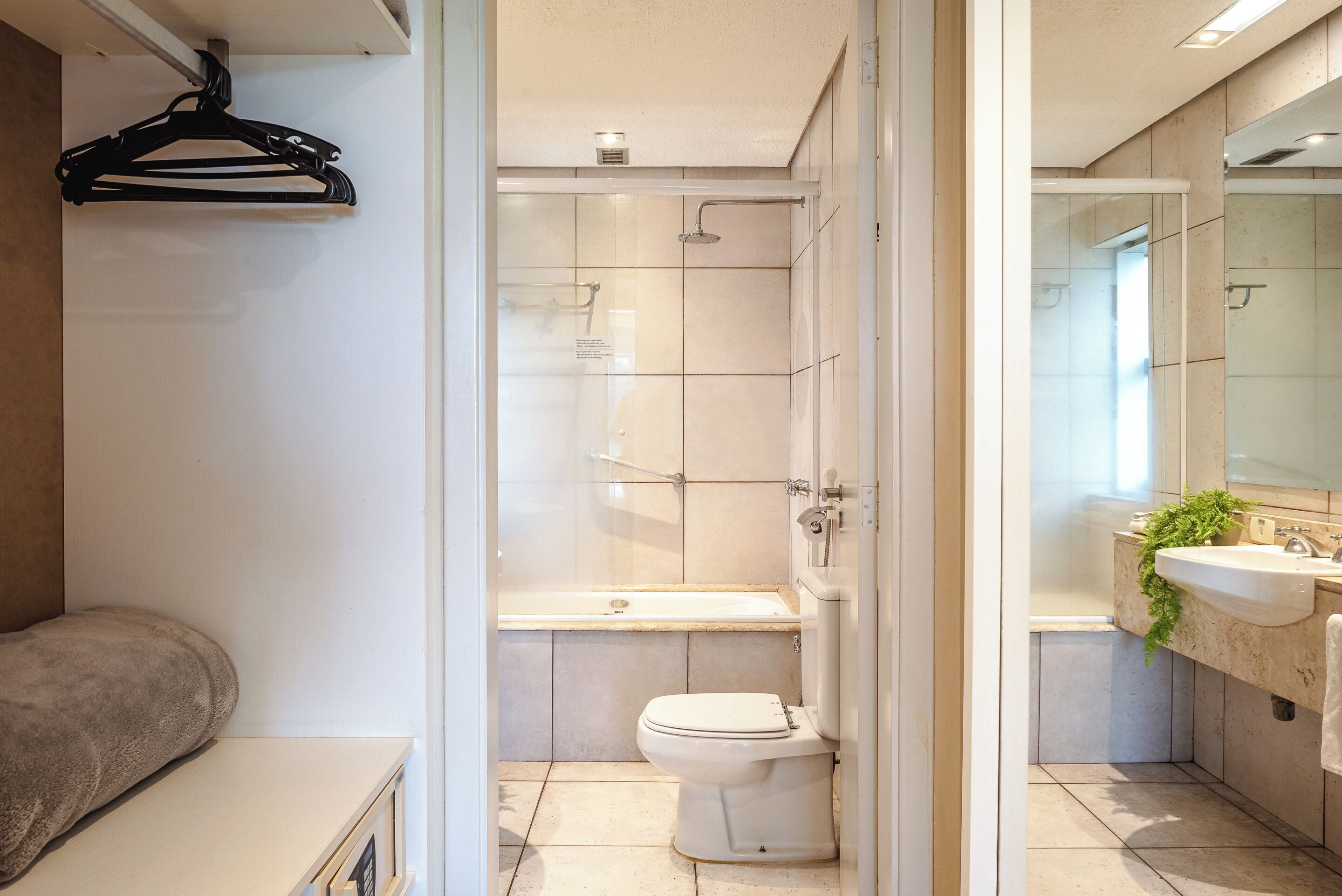 A modern bathroom with a glass shower enclosure, a bathtub, and a toilet.
