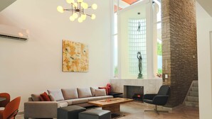 Un salon moderne comprenant un canapé, des poufs, une table basse et une cheminée.