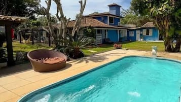 Relax by the pool surrounded by lush greenery and a hammock.