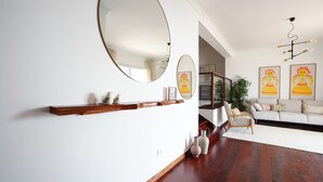 Een moderne woonkamer met een houten plank, twee ronde spiegels, een bank en een salontafel.