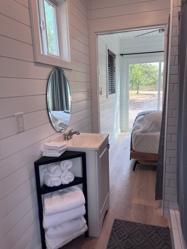 Une salle de bain équipée d’un lavabo, d’un miroir et d’un porte-serviettes.