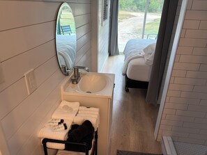 Een badkamer met een wastafel, spiegel en handdoeken.