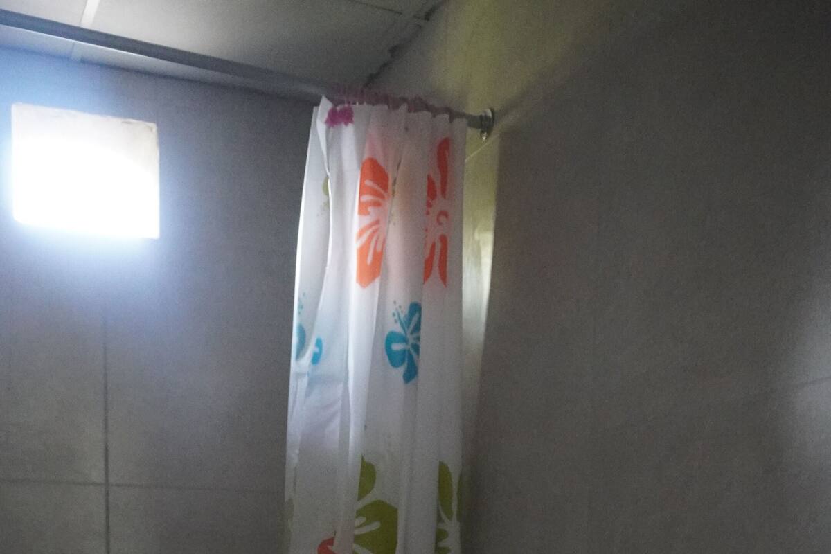 Un baño pequeño con inodoro y cortina de ducha.
