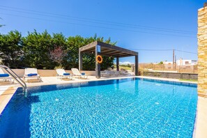 Una piscina con lettini e una zona coperta.