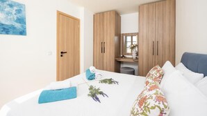 Ein Schlafzimmer mit Bett, Kleiderschrank, Spiegel und einem Bild an der Wand.
