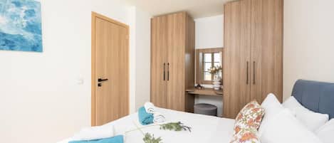 Quarto com cama, guarda-roupa, espelho e um quadro na parede.