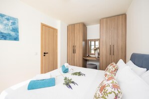 Ein Schlafzimmer mit Bett, Kleiderschrank, Spiegel und einem Bild an der Wand.