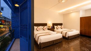 A hotel room with two beds, a balcony, and a view of a city street. - The Rice Hotel & Tour - 131 Bui Vien (Ho Chi Minh City)