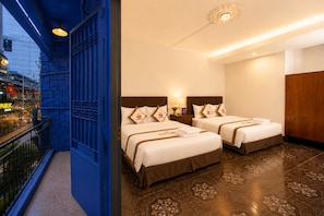 A hotel room with two beds, a balcony, and a view of a city street. - The Rice Hotel & Tour - 131 Bui Vien (Ho Chi Minh City)
