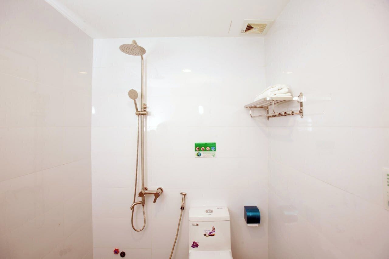 Een badkamer met douche, toilet en handdoekrek.