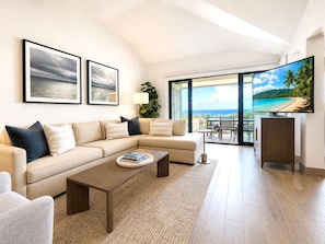 A modern living room with a beige sectional sofa, a coffee table, and a TV on a wooden cabinet.