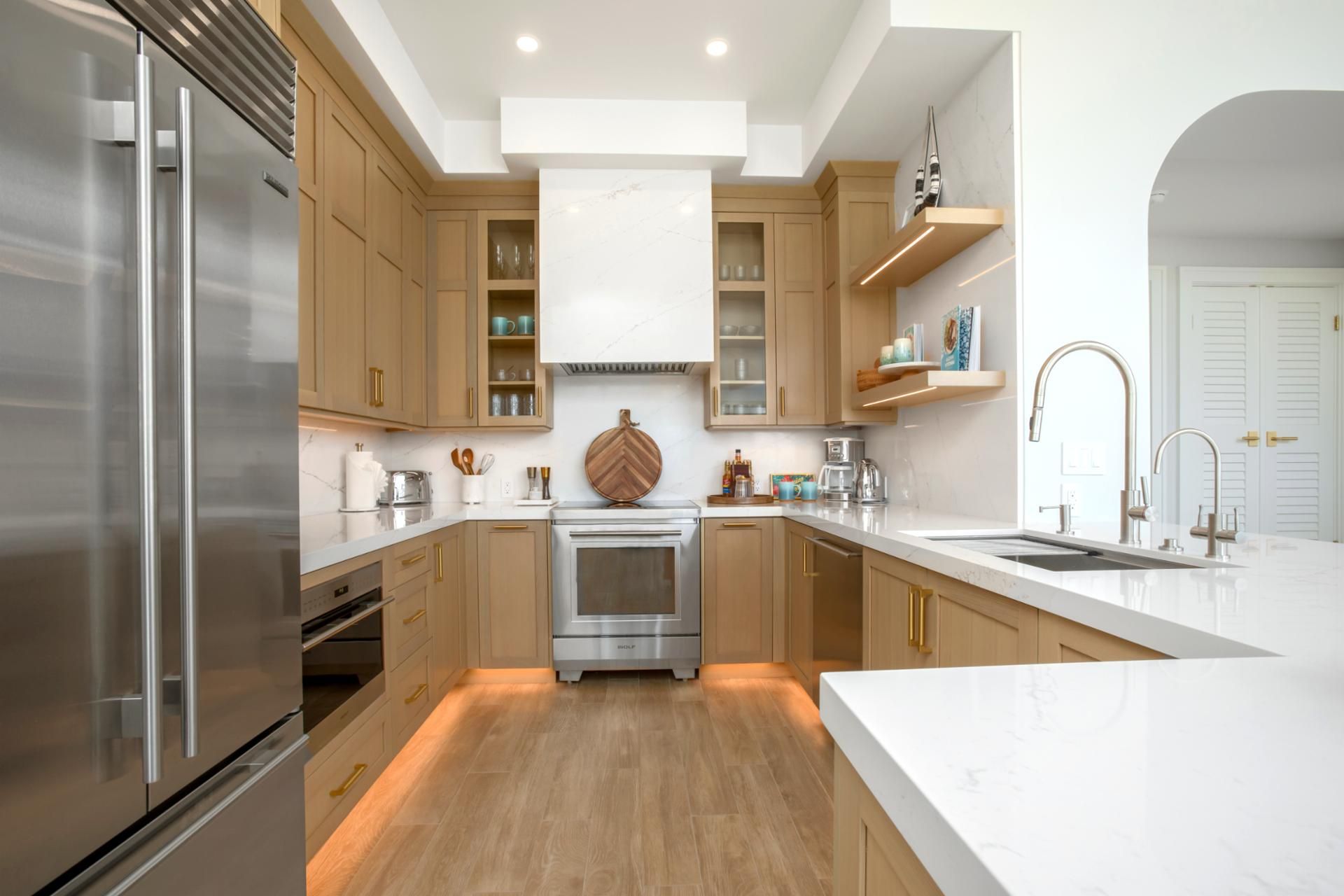 A modern kitchen with stainless steel appliances, wooden cabinets, and a marble backsplash.