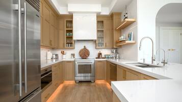 A modern kitchen with stainless steel appliances, wooden cabinets, and a marble backsplash.