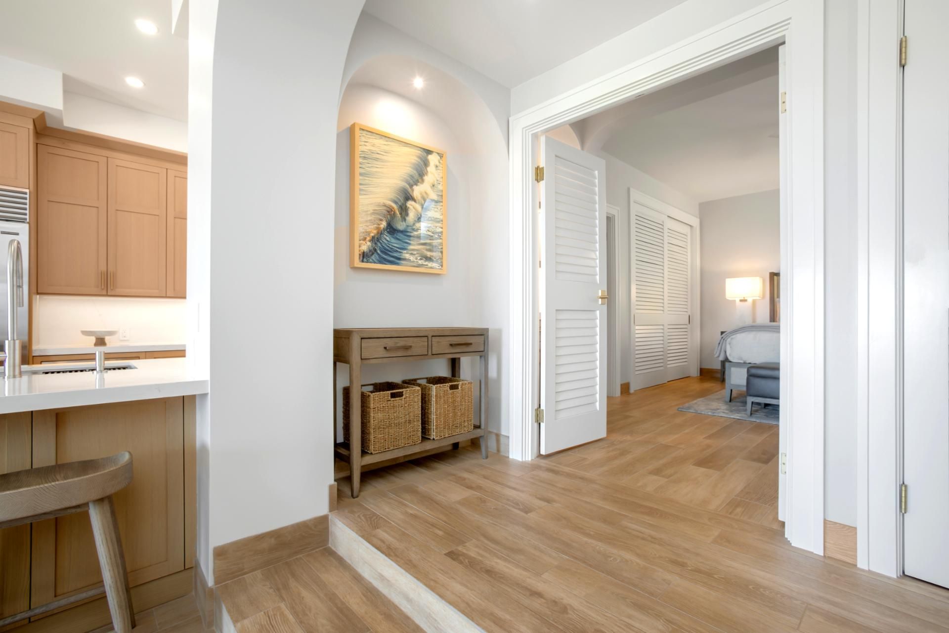 Eine moderne Küche mit Holzschränken, einer Spüle aus Edelstahl und einem Essbereich mit einer Bank.